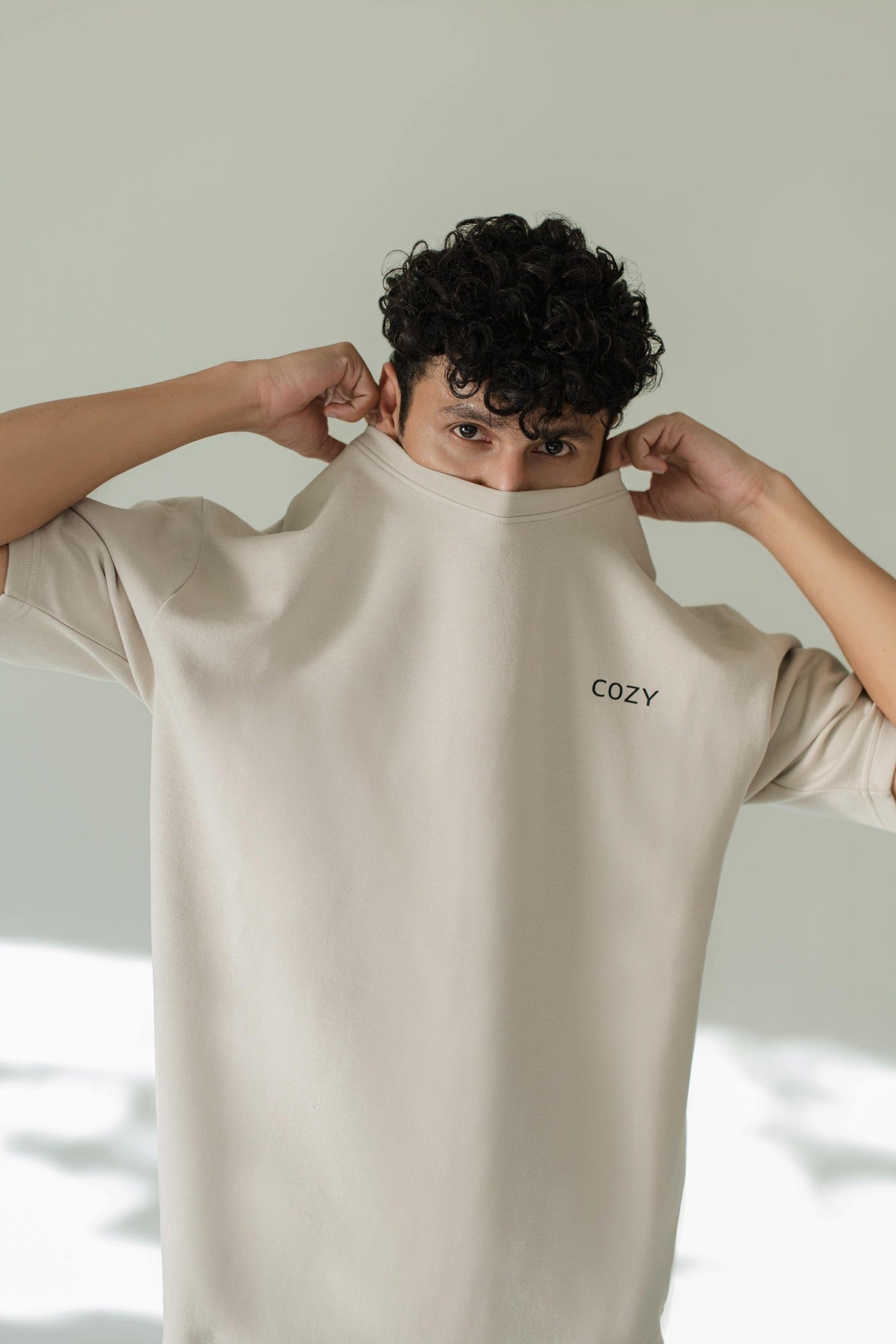 Model wearing a cozy organic cotton sweatshirt, showcasing comfort and style in a light hue.