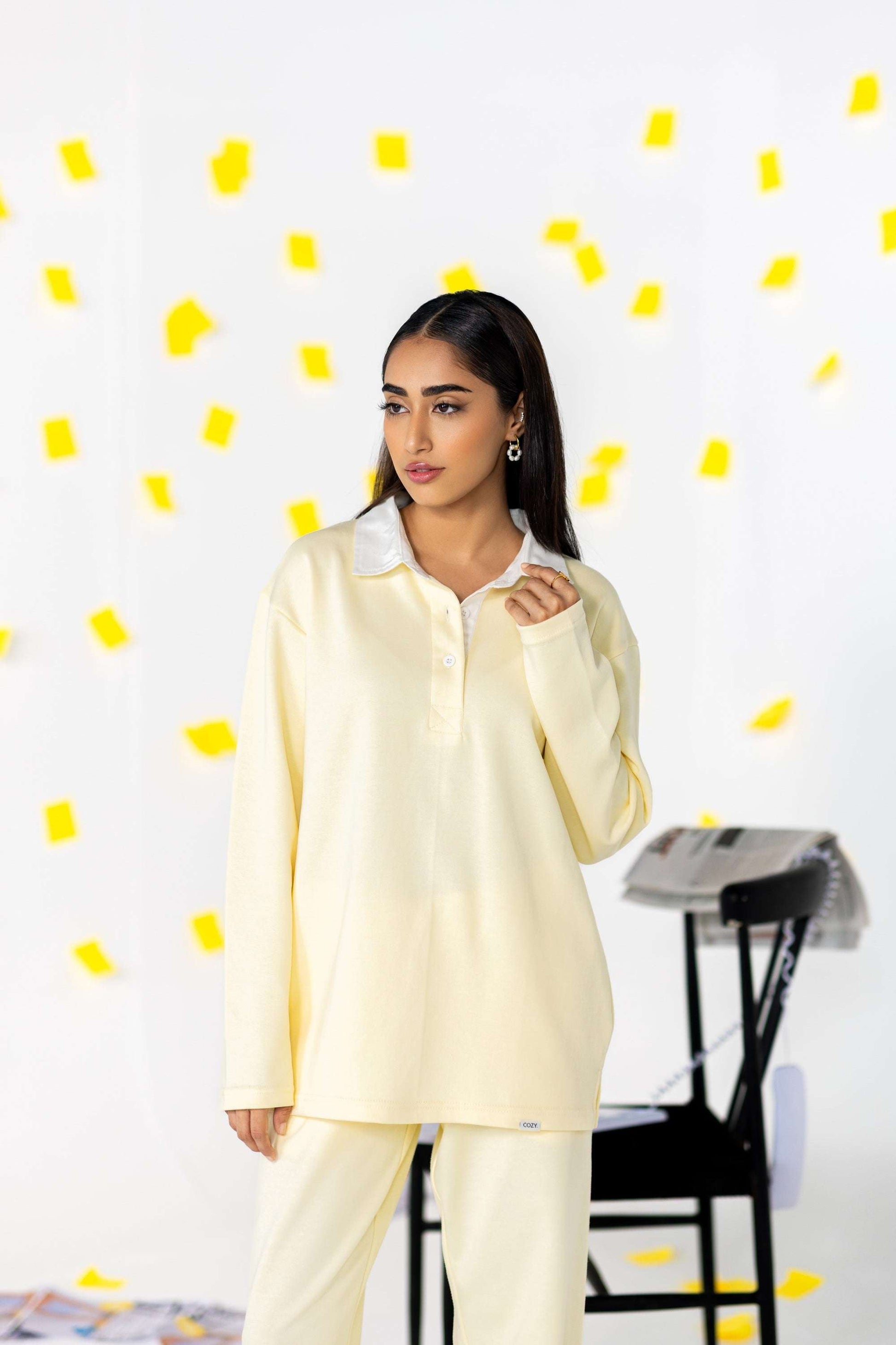 Model wearing the COZY Ladies Rugby Polo in soft yellow, showcasing its relaxed fit and modern style.