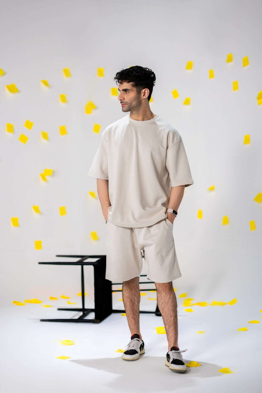 Model wearing COZY Shorts V2 and a relaxed fit top, showcasing organic cotton style against a colorful backdrop.