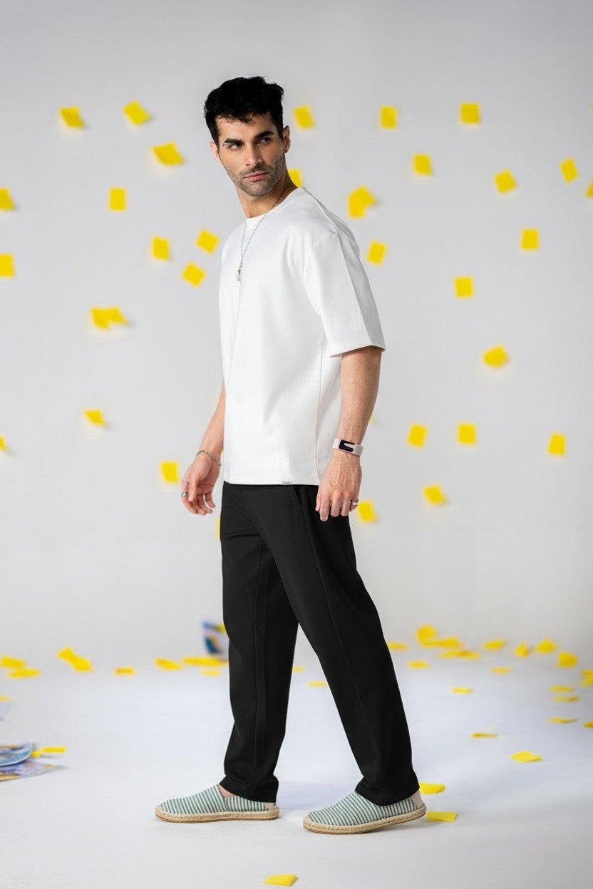 Model wearing COZY Men's Classic Fit Pants with a white shirt and stylish shoes against a colorful backdrop.