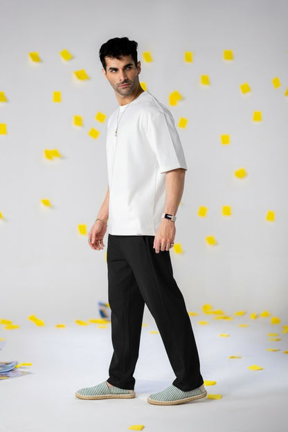 Model wearing COZY Men's Classic Fit Pants with a white shirt and stylish shoes against a colorful backdrop.