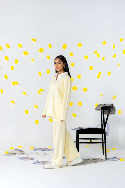 COZY Ladies Rugby Polo in soft yellow with relaxed fit, set against playful background of yellow sticky notes.