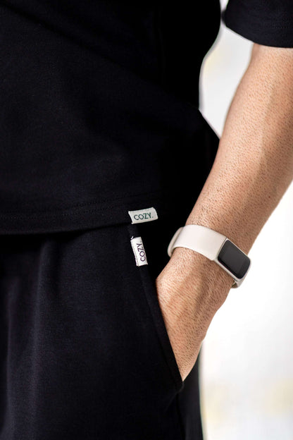 Close-up of a man wearing COZY Shorts V2 with relaxed fit, showcasing the COZY label and a sporty watch.