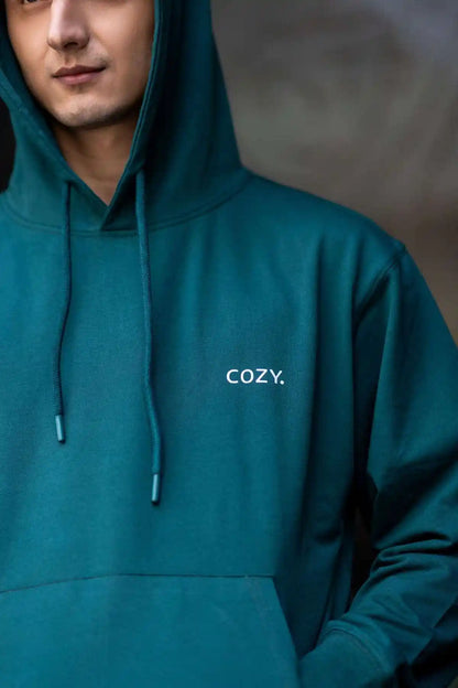 Close-up of the COZY Men's Hoodie in Jade Brew showing the small COZY logo on the chest, drawstrings and hood