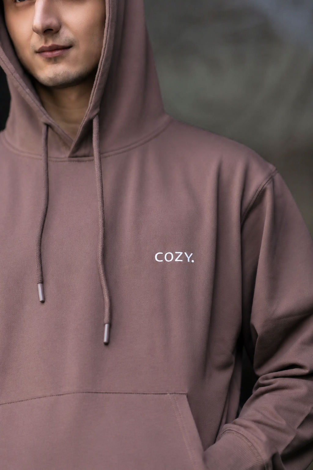 Close-up of the COZY Men's Hoodie in Mocha Mousse showing the small COZY logo on the chest, drawstrings and hood