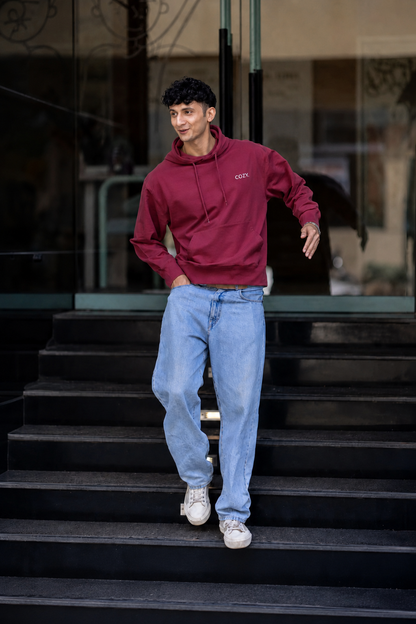 Man walking down dark steps in the COZY Men's Hoodie in Mulberry Mocha with light wash jeans and white sneakers