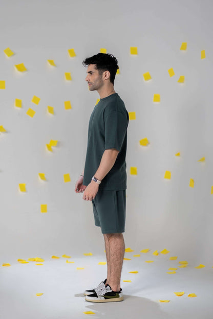 Man wearing COZY Shorts V2 in relaxed fit, showcasing organic cotton comfort and fall fit, surrounded by yellow confetti.
