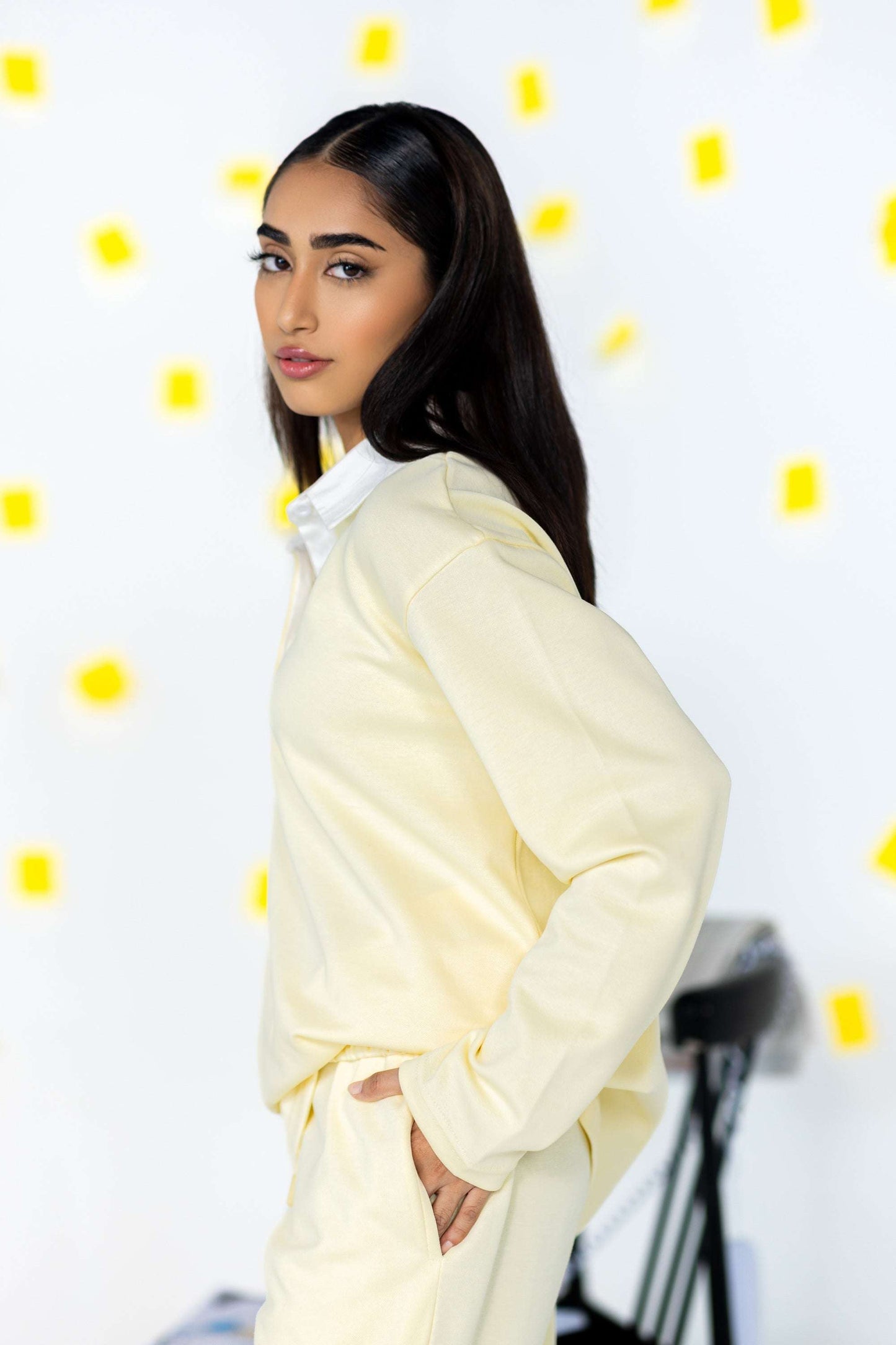 Model wearing COZY Ladies Rugby Polo in light yellow against a backdrop of yellow sticky notes.
