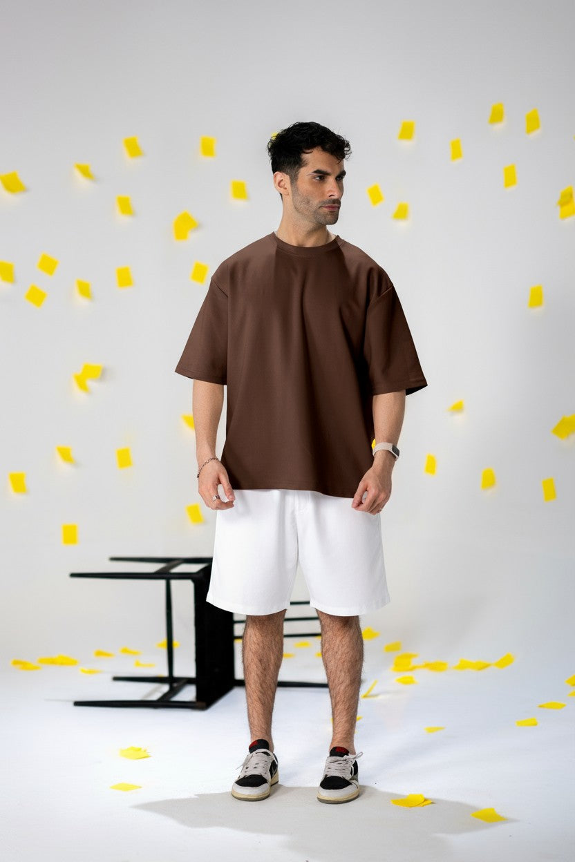 Model wearing COZY Shorts V2 in white with a brown top, surrounded by yellow paper confetti.