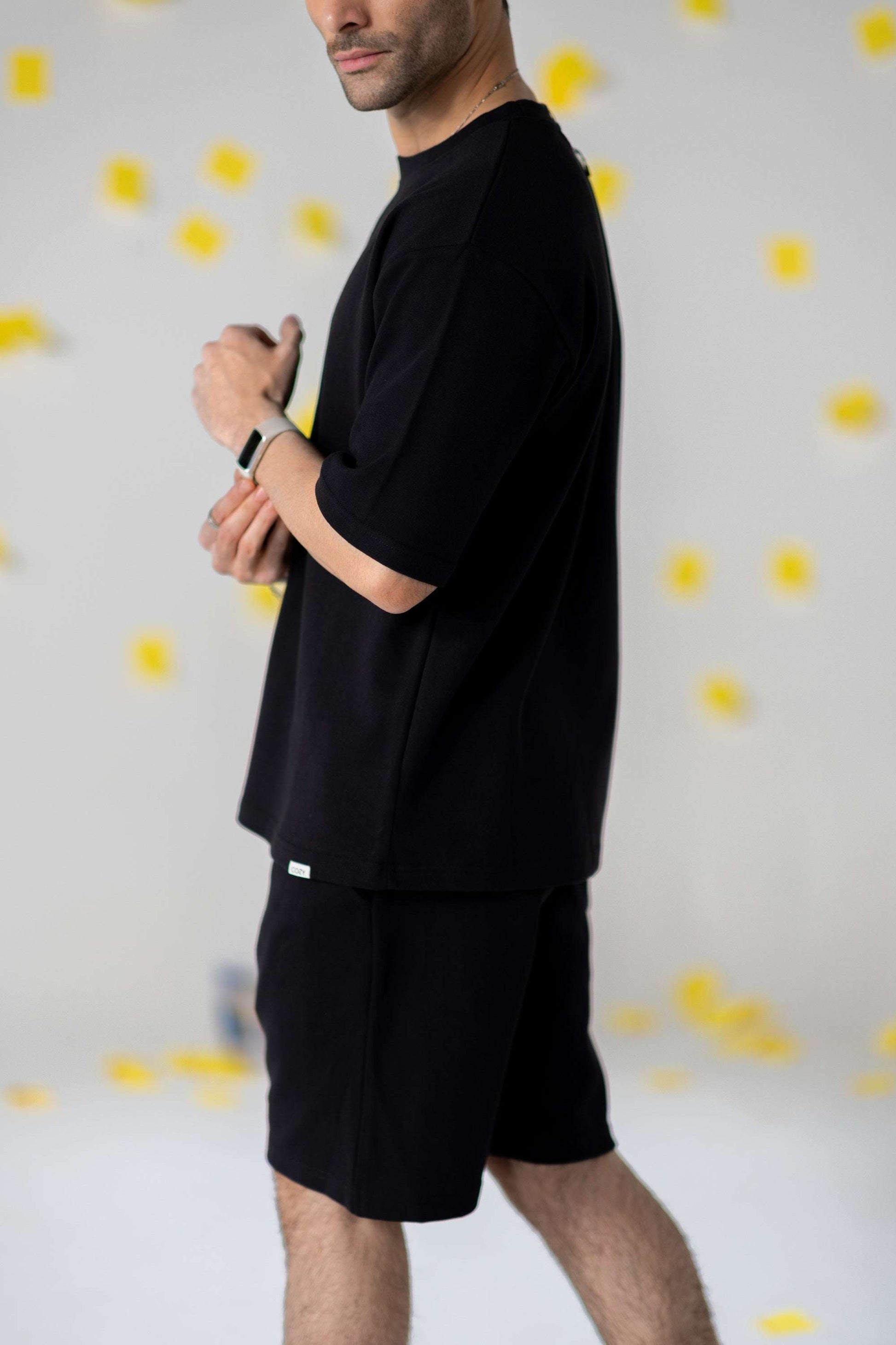 Model wearing COZY Shorts V2 in relaxed fit, showcasing organic cotton material and stylish black design.