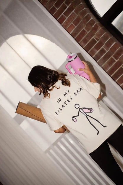 In My Pilates Era oversized tee in COZY Cotton, back print worn by model with pilates bag