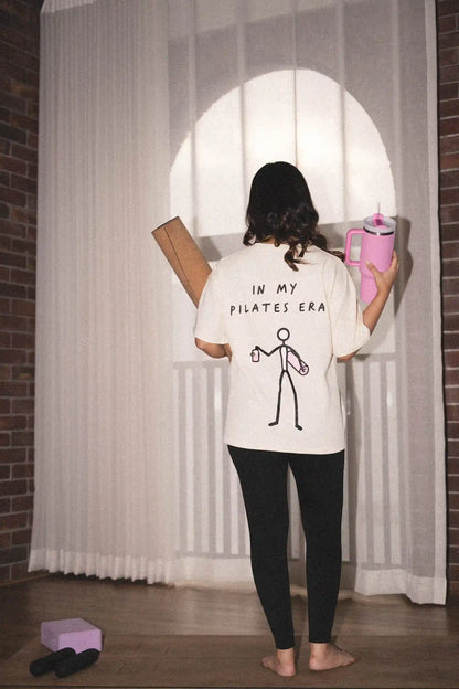 In My Pilates Era oversized tee in COZY Cotton, back print worn by model with yoga mat